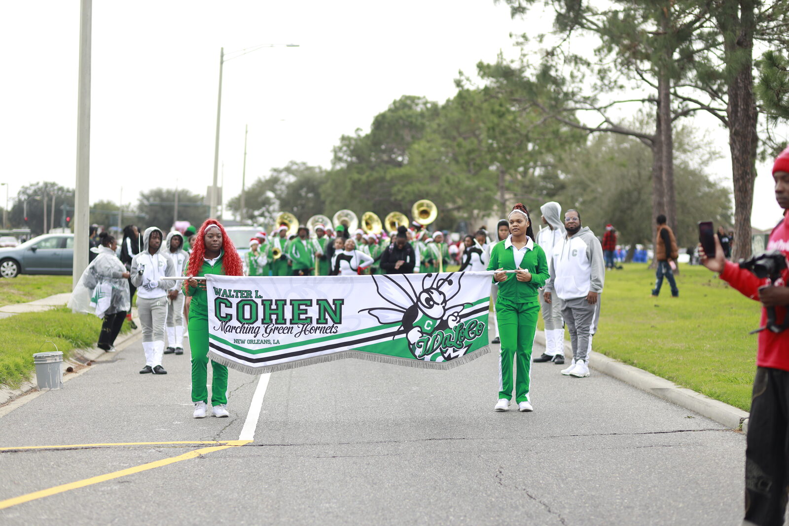 Student banner carriers lead the Walter L. Cohen marching band down the boulevard